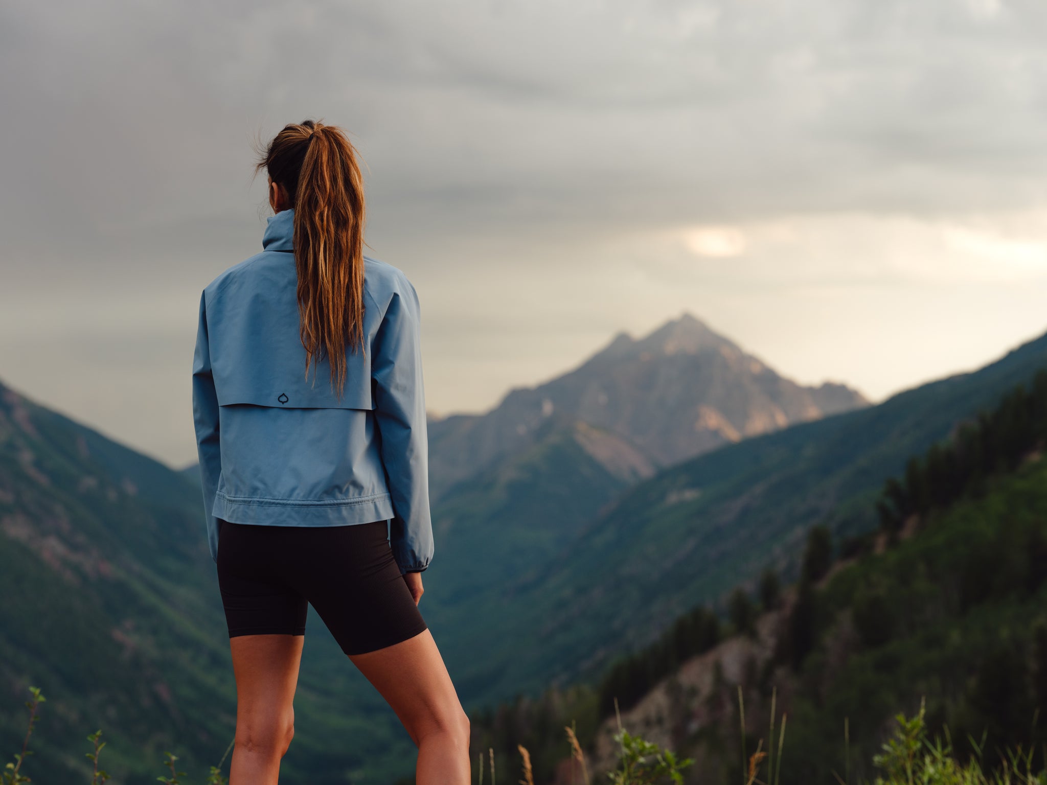 Woman wearing ASPENX Shavano Jacket in front of a mountain landscape